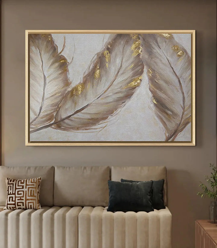 Cuadro Ivory Feathers decorando un salón con cojines dorados