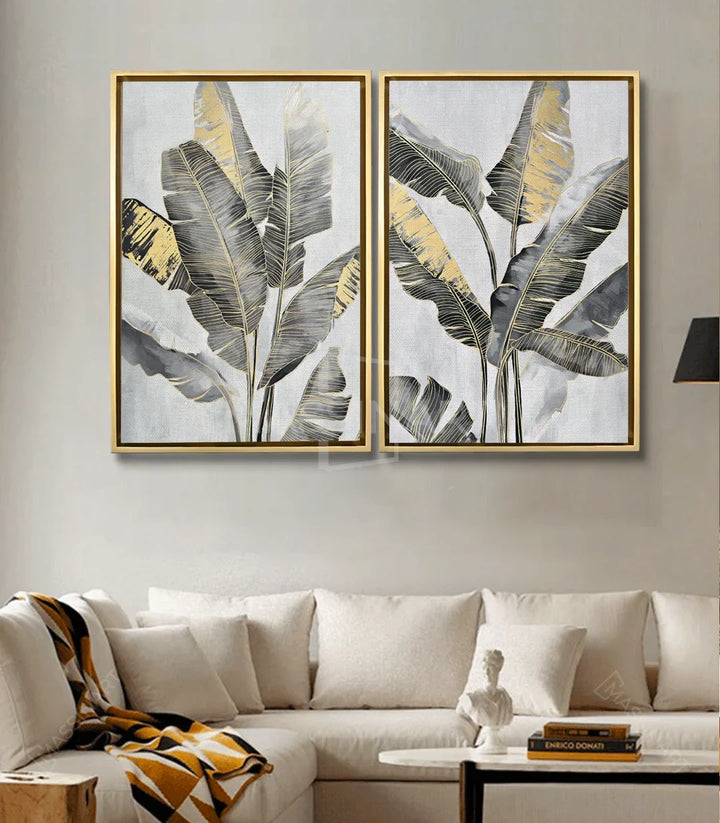 Díptico Banana Leaves en salón moderno — cuadro botánico dorado y gris sobre sofá