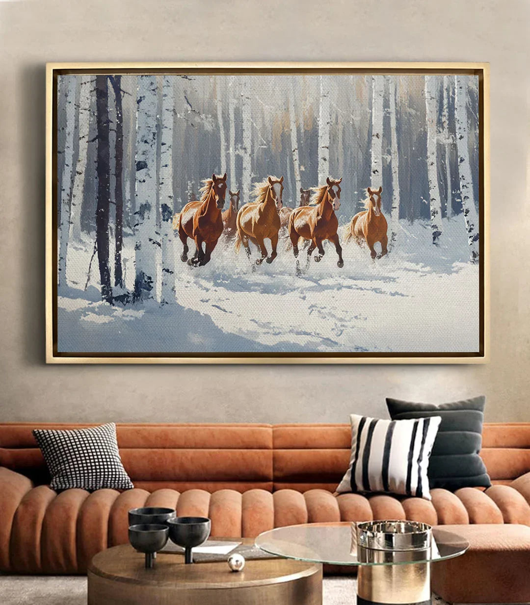 Cuadro de caballos en la nieve en un salón moderno sobre sofá de cuero color coñac