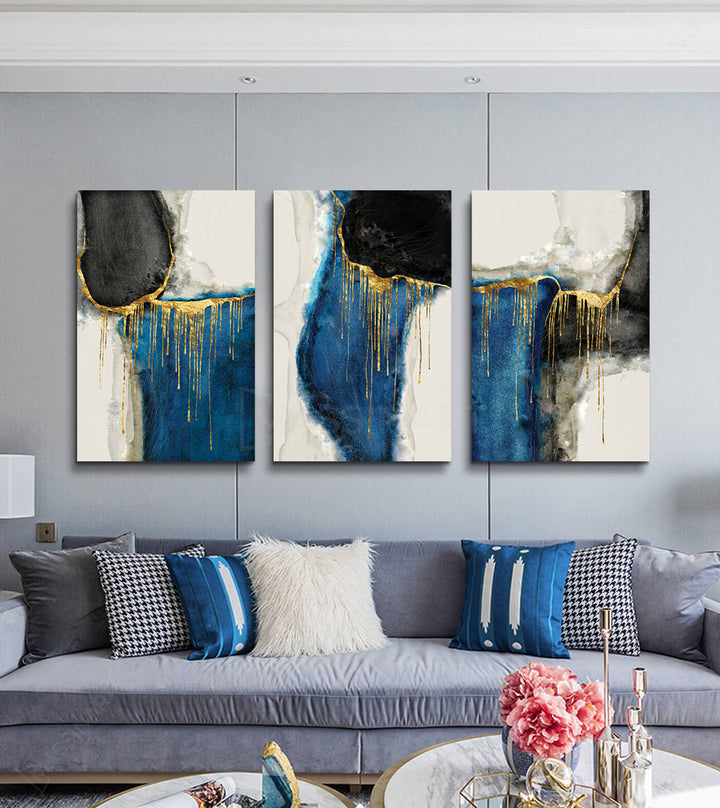 Decoración salón moderno — tríptico abstracto azul y dorado colgado sobre sofá beige