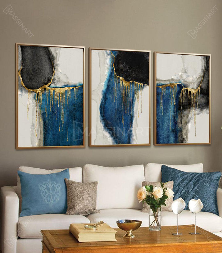 Cuadro abstracto azul y dorado en tríptico — formas negras y blancas con dripping dorado sobre lienzo